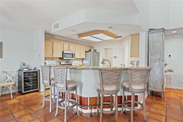 107 Angelfish, Aransas Pass, TX 78336 - kitchen featuring stainless steel appliances, wine cooler, a peninsula, and a breakfast bar