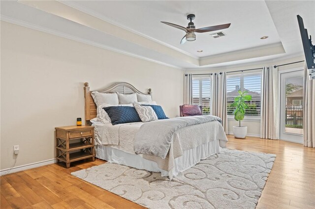 107 Angelfish, Aransas Pass, TX 78336 - bedroom with a tray ceiling, light wood-style flooring, access to exterior, crown molding, and ceiling fan