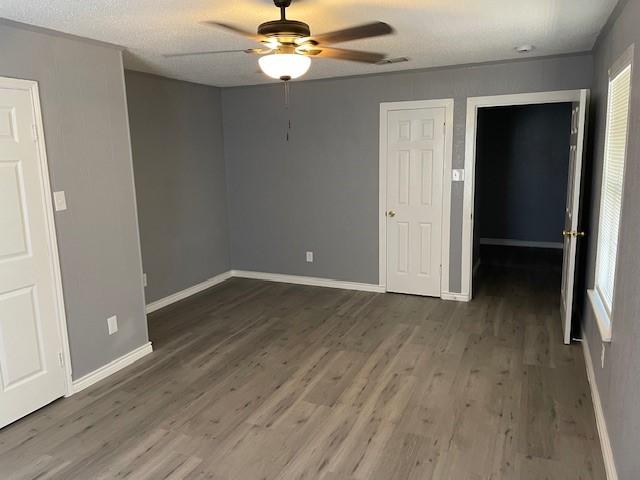 unfurnished bedroom with a ceiling fan, baseboards, and wood finished floors