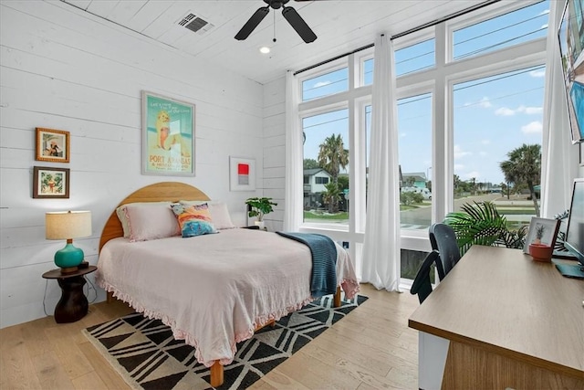 602 Island Retreat Ct, Port Aransas, TX 78373 - bedroom with light wood finished floors, wood walls, and ceiling fan