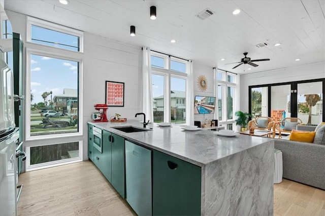 602 Island Retreat Ct, Port Aransas, TX 78373 - kitchen with green cabinets, open floor plan, appliances with stainless steel finishes, light wood-style floors, and healthy amount of natural light