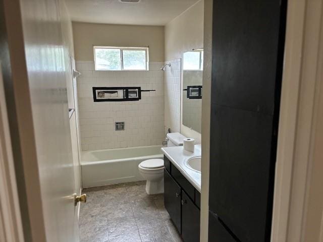 full bathroom with tiled shower / bath, vanity, and toilet