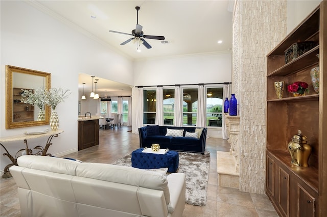 living room featuring ornamental molding, ceiling fan, and a high ceiling