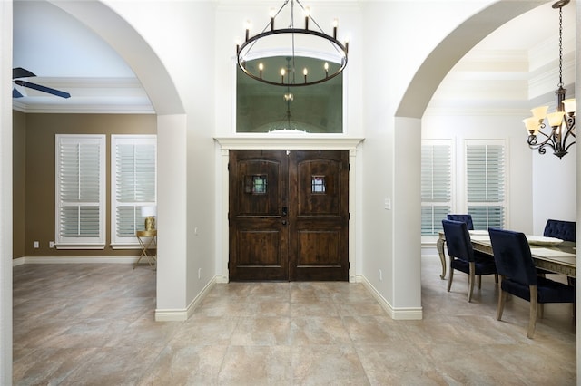 entrance foyer with ornamental molding and ceiling fan with notable chandelier