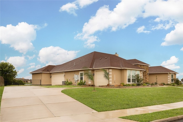 view of front of home with a garage, a front yard, and central air condition unit