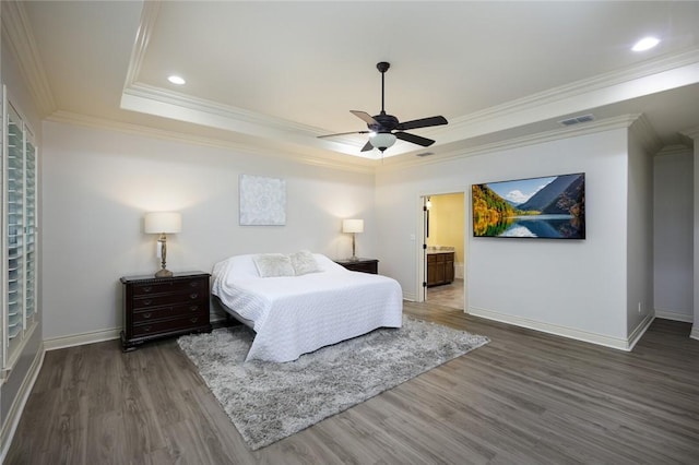 bedroom featuring ensuite bath, ceiling fan, a tray ceiling, ornamental molding, and dark hardwood / wood-style flooring