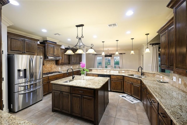 kitchen with dark brown cabinetry, sink, decorative light fixtures, an island with sink, and stainless steel appliances