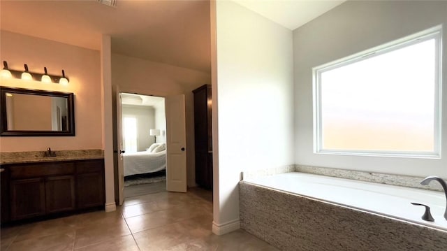 bathroom featuring tile patterned floors, vanity, and a washtub