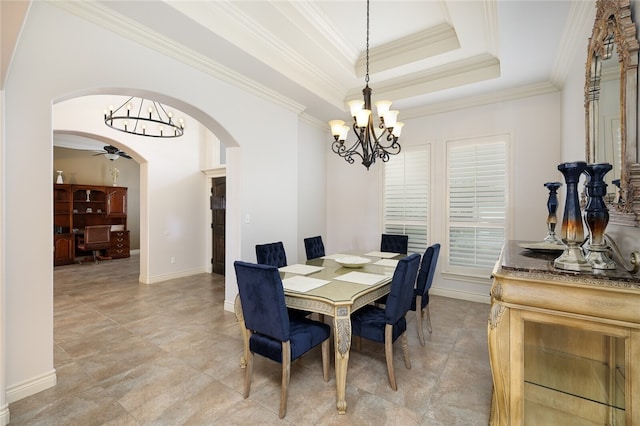 dining area featuring crown molding, a tray ceiling, and ceiling fan with notable chandelier