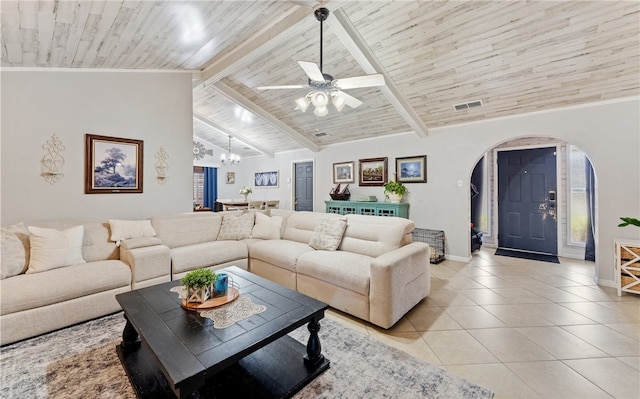 living area featuring arched walkways, beam ceiling, light tile patterned flooring, wooden ceiling, and baseboards