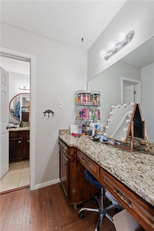 bathroom with vanity, baseboards, and wood finished floors