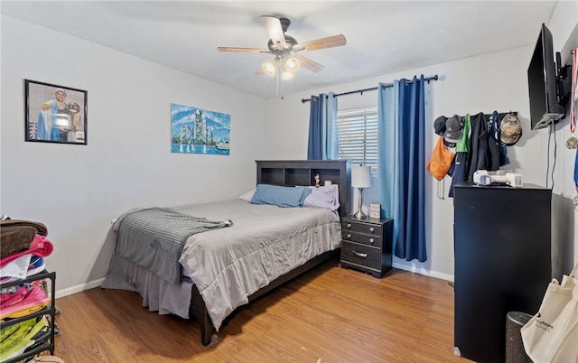 bedroom with light wood-style flooring, baseboards, and a ceiling fan