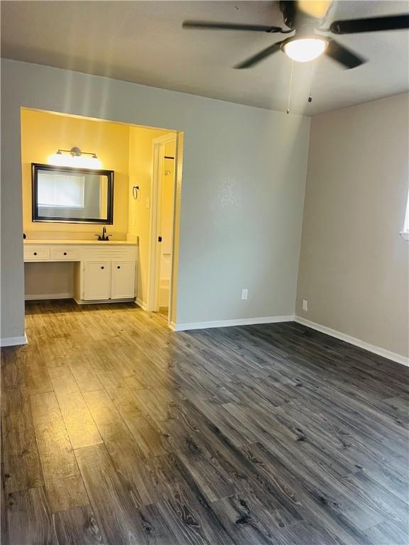 4006 Hurlwood, Corpus Christi, TX 78410 - unfurnished bedroom with dark wood-type flooring, baseboards, ensuite bathroom, and ceiling fan