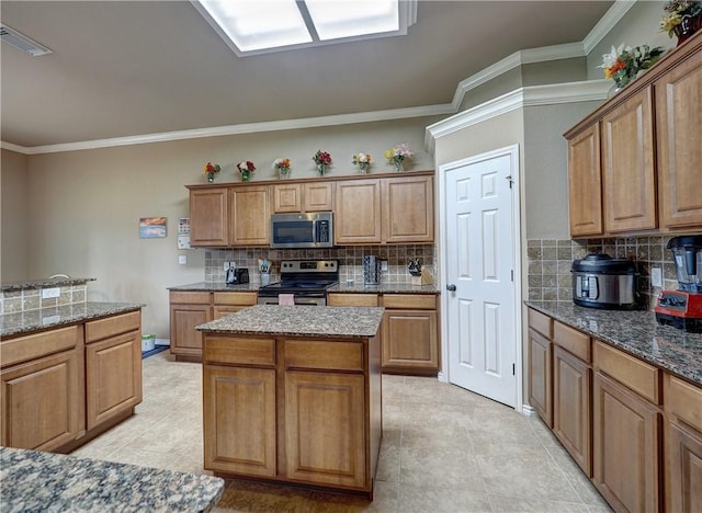 kitchen with tasteful backsplash, a kitchen island, stainless steel appliances, and ornamental molding
