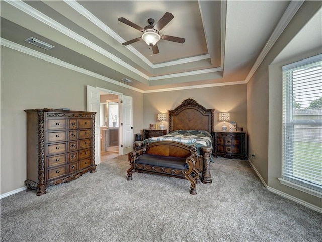 carpeted bedroom featuring baseboards, visible vents, ornamental molding, and a raised ceiling