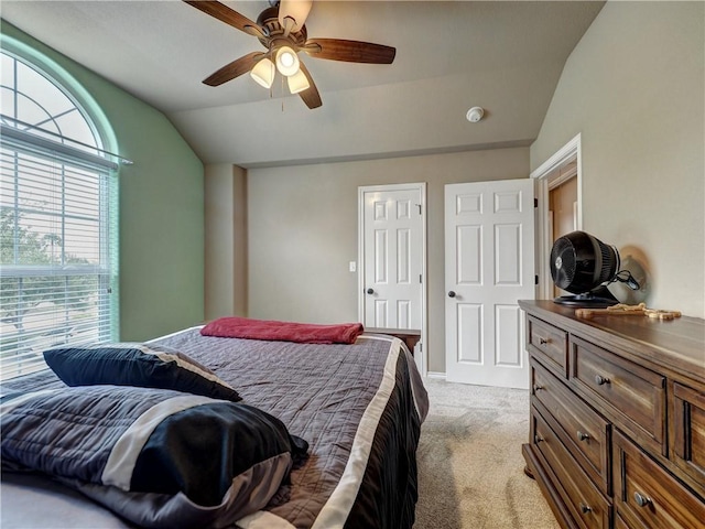 bedroom with ceiling fan, light colored carpet, and lofted ceiling