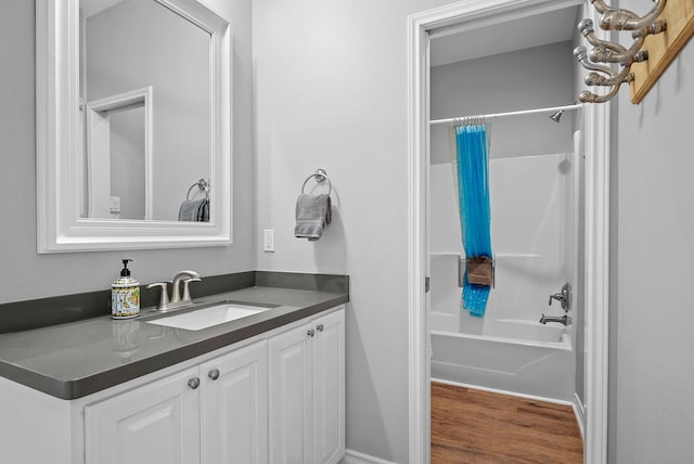 bathroom with wood finished floors, vanity, and shower / tub combo with curtain