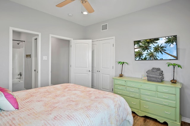 bedroom with visible vents, a ceiling fan, connected bathroom, dark wood-style flooring, and a closet