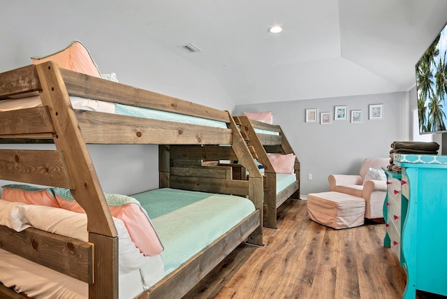 bedroom with recessed lighting, visible vents, vaulted ceiling, and wood finished floors