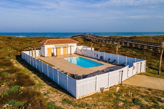 view of swimming pool with a patio area, a water view, a fenced backyard, and a fenced in pool