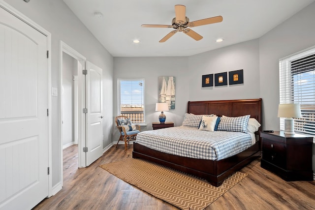 bedroom featuring multiple windows, baseboards, wood finished floors, and recessed lighting