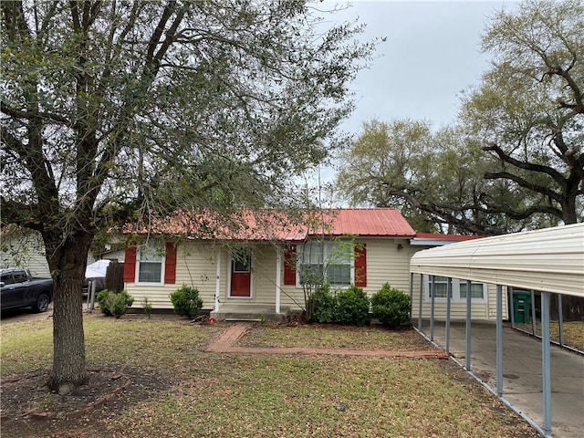 view of front facade with metal roof, a front yard, and a carport