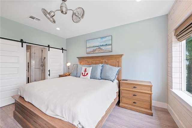 145 Beachwalk Prt, Aransas, TX 78373 - bedroom featuring a barn door, light wood-style floors, recessed lighting, and a chandelier