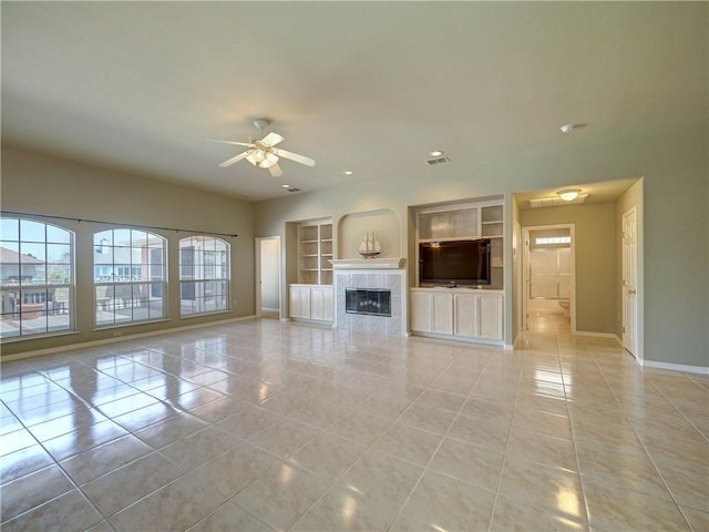 unfurnished living room featuring light tile patterned floors, built in shelves, a high end fireplace, and ceiling fan