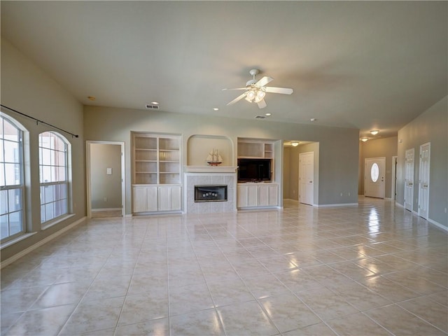 unfurnished living room featuring ceiling fan, a tile fireplace, and light tile patterned floors