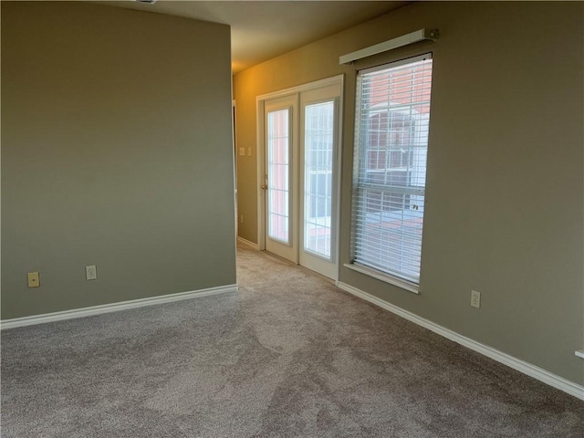 carpeted spare room featuring plenty of natural light