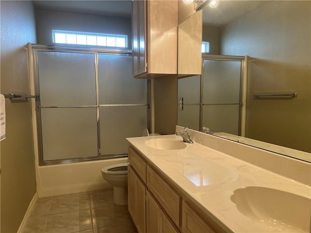 full bathroom with toilet, tile patterned floors, bath / shower combo with glass door, and vanity