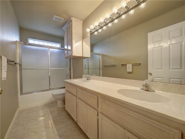 full bathroom with tile patterned flooring, vanity, shower / bath combination with glass door, and toilet