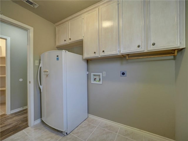 laundry area with hookup for a washing machine, light tile patterned flooring, hookup for an electric dryer, and cabinets