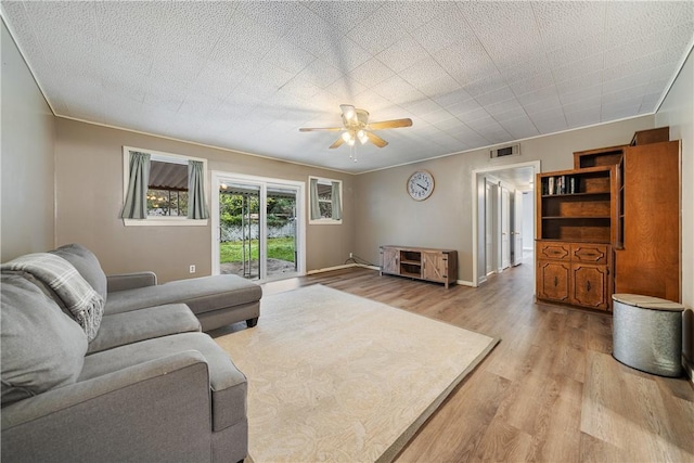 living room featuring ceiling fan and light hardwood / wood-style floors