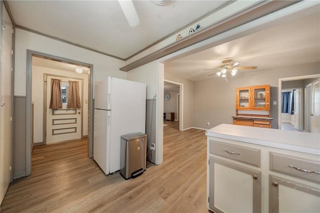 kitchen featuring light hardwood / wood-style flooring, white fridge, ornamental molding, white cabinets, and ceiling fan