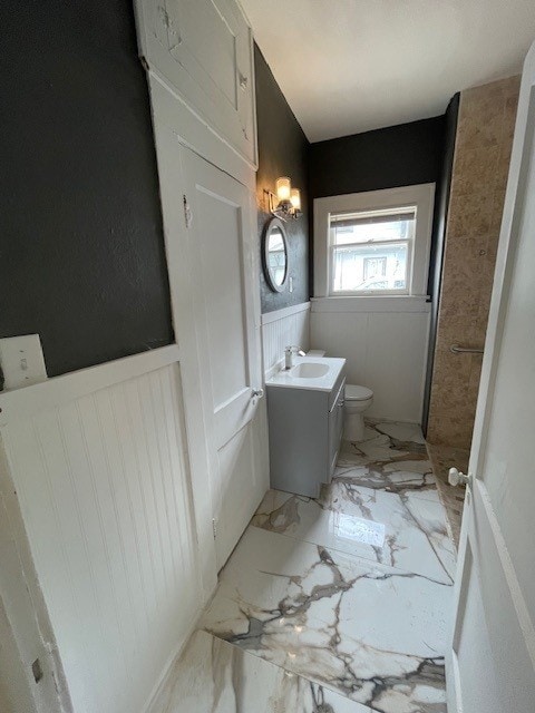 415 W King Ave, Kingsville, TX 78363 - bathroom featuring wainscoting, toilet, vanity, and marble finish floors