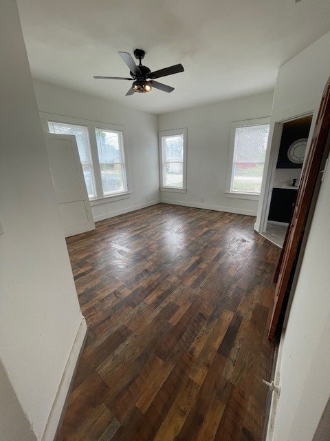 415 W King Ave, Kingsville, TX 78363 - unfurnished living room with dark wood finished floors, a ceiling fan, and baseboards