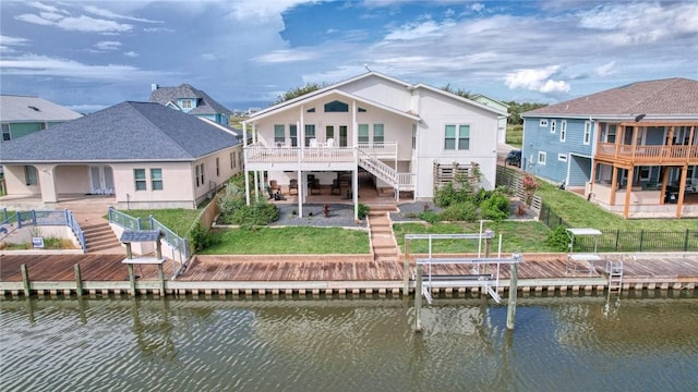 rear view of house featuring a lawn, a patio area, and a water view