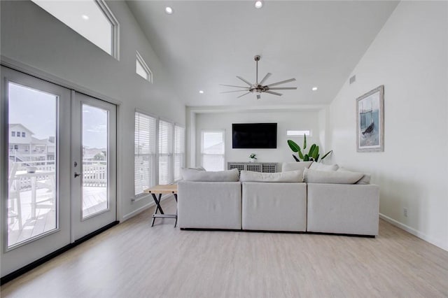 living room with ceiling fan, french doors, plenty of natural light, and light hardwood / wood-style flooring