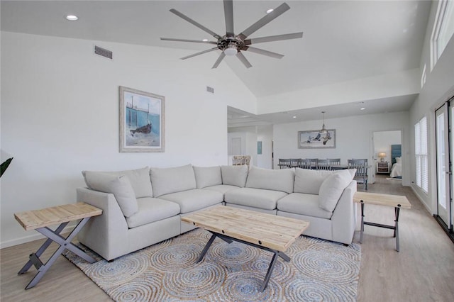 living room featuring light wood-type flooring, high vaulted ceiling, and ceiling fan