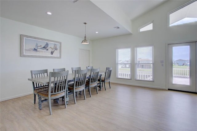 dining room with vaulted ceiling and light wood-type flooring