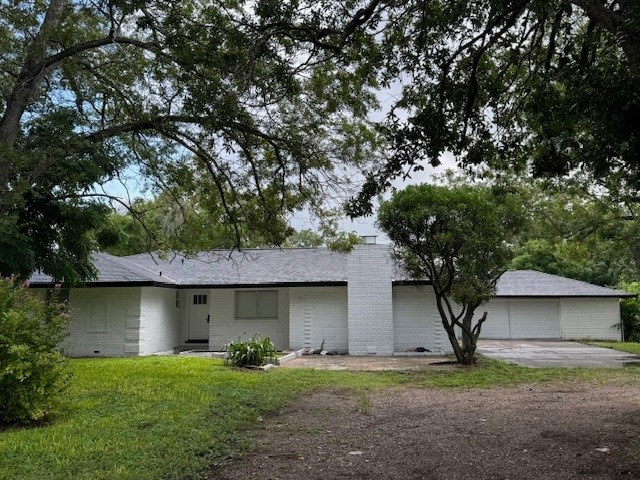 rear view of property with a lawn and a garage