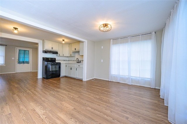 unfurnished living room with light wood-type flooring and a sink