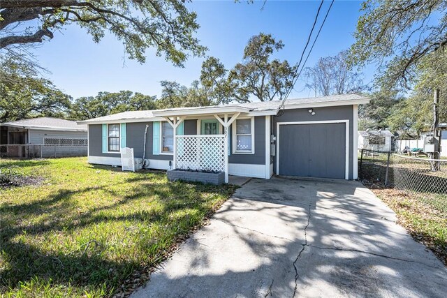 view of front facade featuring concrete driveway, a front lawn, an attached garage, and fence