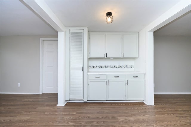 bar featuring white cabinets and dark hardwood / wood-style flooring