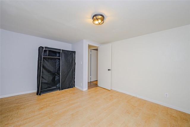 empty room with light wood-style floors and baseboards