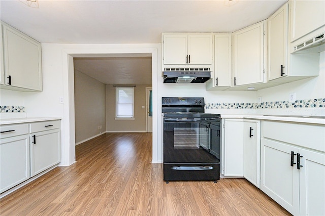 kitchen featuring under cabinet range hood, electric range, light wood-style floors, white cabinets, and light countertops