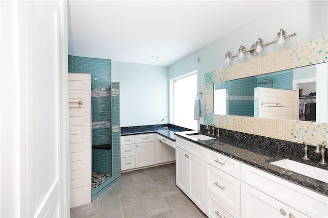 15354 Caravel Dr, Corpus Christi, TX 78418 - bathroom with a stall shower, double vanity, tile patterned flooring, a spacious closet, and decorative backsplash