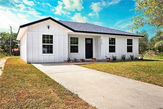 936 S 10th St, Aransas Pass, TX 78336 - view of front of home featuring board and batten siding, a shingled roof, and a front yard