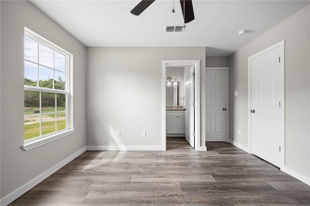 936 S 10th St, Aransas Pass, TX 78336 - unfurnished bedroom featuring baseboards, visible vents, and wood finished floors